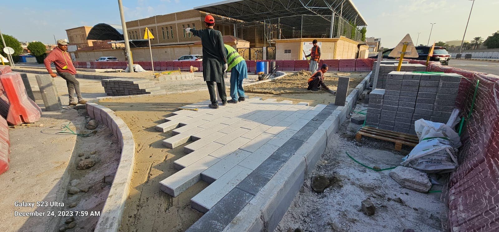 Crew installing paving stones by hand