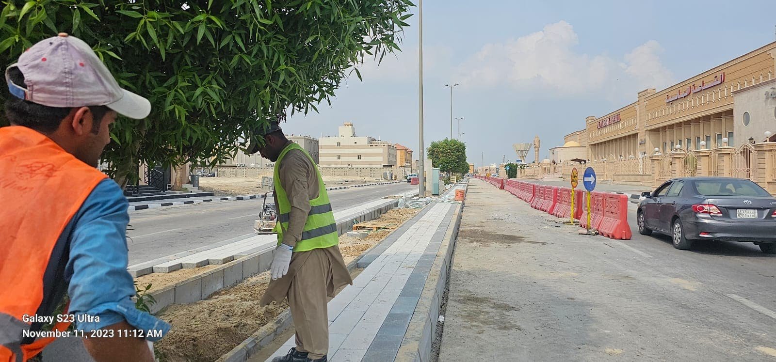 Sidewalk installation crew near a public building